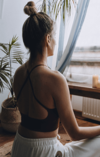 Woman practicing meditation in a calm indoor wellness space, representing holistic health and AI-enabled smart clinic wellness approach