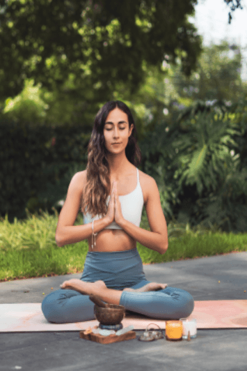 Woman practicing yoga and meditation outdoors, symbolizing holistic wellness, preventive care, and balance supported by AI-enabled smart clinic solutions